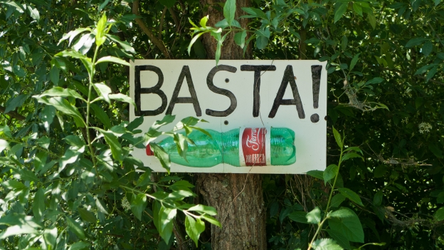 Sign on a roadside in the Veneto appealing to motorists not to throw bottles out of the window: 'basta' means 'enough'
