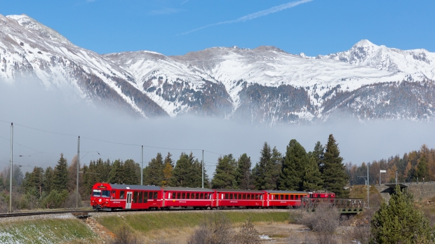 Red RHB train near Pontresina in the Swiss Alps