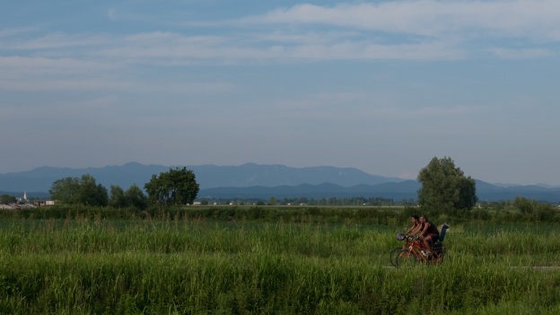 Cyclists on the Ciclovia Alpe-Adria Radweg (FVG1) cycleway as it passes Aquileia