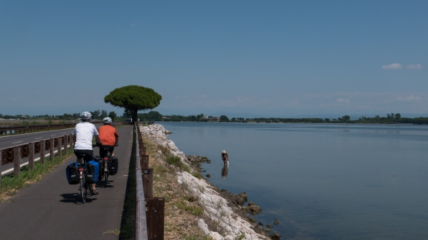 Cyclists on the Ciclovia Alpe-Adria Radweg (FVG1) cycleway on the causeway to Grado