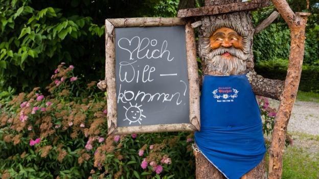 Figure outside the Pircher restaurant near Nals Blue-aproned figure outside the Pircher restaurant near Nals