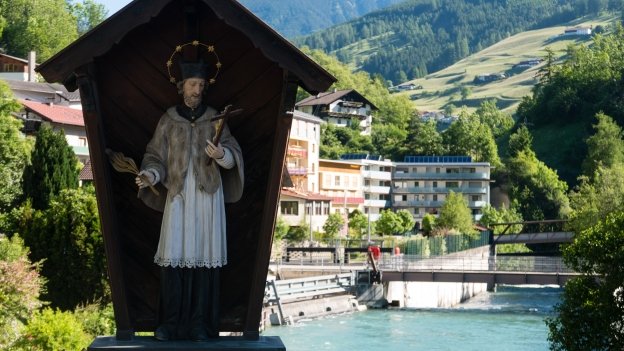 Figure of the saint Johannes Nepomuk on the bridge over the river at Matrei am Brenner