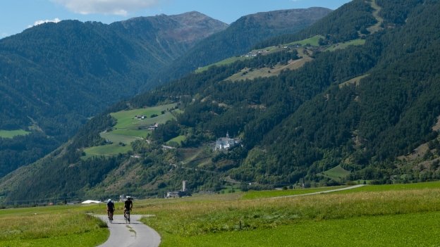 Cycle route near Burgeis Cyclists riding a cycle route near Burgeis with the Stift Marienberg (Marienberg Abbey) in the distance